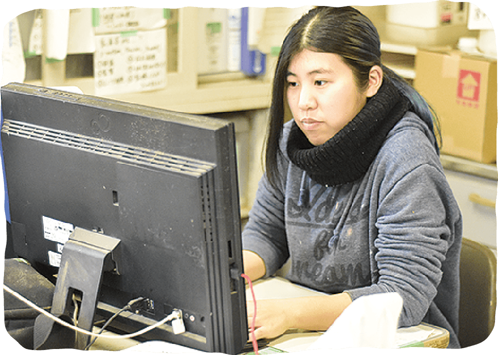 パソコンで牛の状態を管理している女性